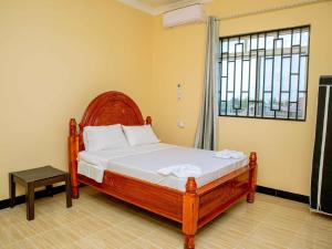 a bedroom with a bed with a large window at Nungwi Modern Apartment 2 in Kinyasini