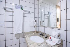 a bathroom with a sink and a mirror at Hotel Express São Leopoldo in São Leopoldo +17 photos