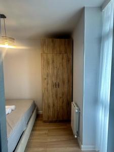 Habitación pequeña con cama y puerta de madera en Bagrationi Apartment with Separate bedroom, en Angisa