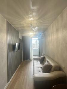 Una sala de estar con un sofá y un televisor en Bagrationi Apartment with Separate bedroom, en Angisa