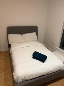 ein Bett mit einer grünen Tasche darüber in der Unterkunft Rooftop 2 Bed Penthouse, Hot Tub, Wrapped Balcony, Free Parking, Train Station Location by Opulent Stays in Derby
