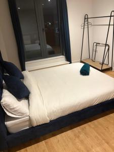 ein Bett in einem Zimmer mit Fenster in der Unterkunft Rooftop 2 Bed Penthouse, Hot Tub, Wrapped Balcony, Free Parking, Train Station Location by Opulent Stays in Derby