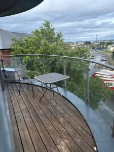 ein Balkon mit einem Tisch und einer Bank auf der Terrasse in der Unterkunft Rooftop 2 Bed Penthouse, Hot Tub, Wrapped Balcony, Free Parking, Train Station Location by Opulent Stays in Derby