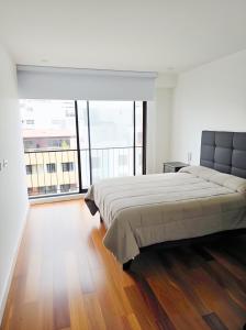 ein Schlafzimmer mit einem großen Bett und einem großen Fenster in der Unterkunft Miraflores habitaciones con baño privado especial para turistas in Lima