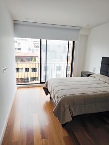 ein Schlafzimmer mit einem Bett und einem großen Fenster in der Unterkunft Miraflores habitaciones con baño privado especial para turistas in Lima