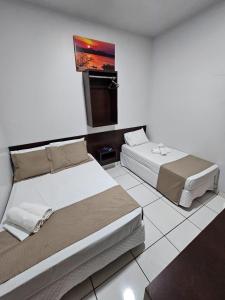 a bedroom with two beds and a tv in it at New Center Hotel in Carolina +34 photos