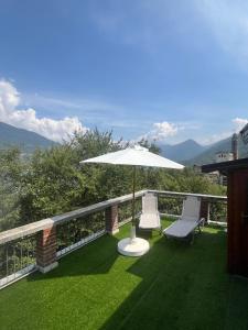 een patio met 2 stoelen en een parasol op het gras bij La Terrazza Panoramica in San Sebastiano +7 foto's
