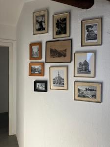 a wall with framed pictures on a wall at Casa di Savio in Altenmedingen