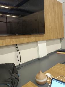 a desk with a laptop and a television on a wall at Lugar único in Dourados