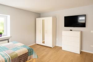 a bedroom with a bed and a flat screen tv at Wohlfühlzimmer Marienheide in Marienheide