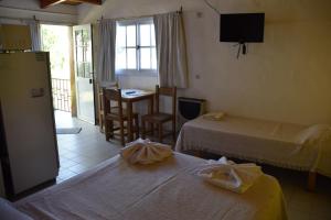 a hotel room with two beds and a table at Complejo El Alto in Tanti +70 photos