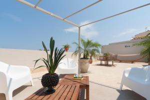 een patio met een tafel en stoelen en een boot bij THE PLACE Ortigia in Siracusa