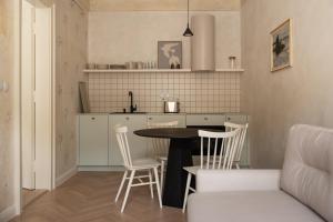 Una cocina con una mesa y sillas en una habitación. en Limewash Apartments Karlsbad, en Karlovy Vary