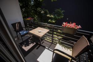 a table and chairs on a balcony with flowers at Dekart 2 in Niš