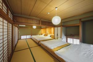 two twin beds in a room with wooden ceilings at Kawashiri no Tomari - Vacation STAY 17885v in Kumamoto