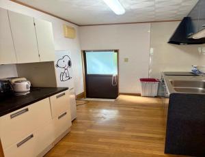 une cuisine avec une porte avec un dessin de chien sur le mur dans l'établissement Biwako Hills - Vacation STAY 04132v, à Takashima