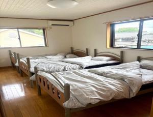 - une rangée de lits dans une chambre avec fenêtres dans l'établissement Biwako Hills - Vacation STAY 04132v, à Takashima