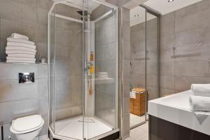 a bathroom with a shower and a toilet and a sink at Fagertoppen 1314B by Vacation Trysil in Mælem +25 photos