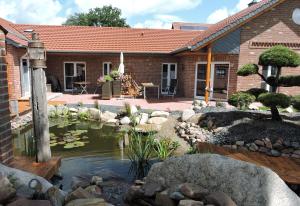 a garden with a pond in front of a house at Apartment am Anker in Uchte