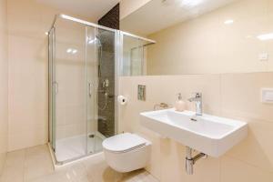 a bathroom with a toilet and a sink and a shower at Beautiful Apartment by Stromovka Park in Prague +4 photos