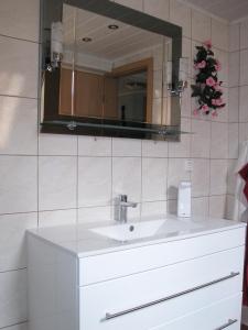 a bathroom with a white sink and a mirror at Ferienwohnung Zawalla in Kamminke