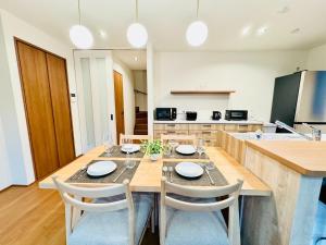 a dining room with a table and chairs and a kitchen at Akikawa Villas 9 - Vacation STAY 18842 in Yuge +1 photo