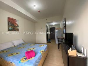 a bedroom with a large bed and a television at Ayins Crib at Vinia Residences North EDSA QC near SM North Trinoma Vertis North in Manila
