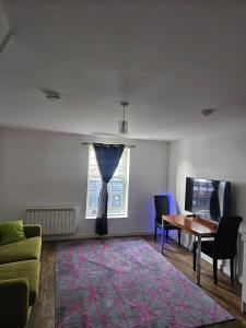 a living room with a table and a tie on a window at Northampton RoomKey in Northampton