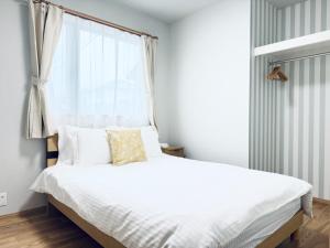 a bedroom with a white bed with a window at Akikawa Villas 13 - Vacation STAY 18846 in Fukumoto