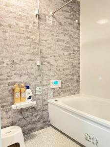 a bathroom with a shower and a white bath tub at Akikawa Villas14 - Vacation STAY 18847 in Fukumoto +26 photos