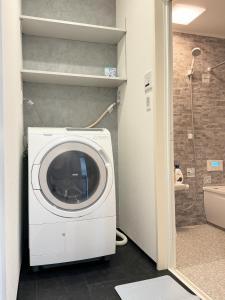 a washing machine in a bathroom with a shower at Akikawa Villas14 - Vacation STAY 18847 in Fukumoto