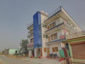 a tall building with a blue facade on a street at SPOT ON Chandra's Residence in Dehradun