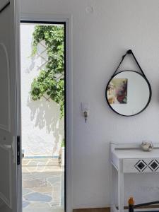 a mirror hanging on a wall next to a door at Rania Studios in Poros