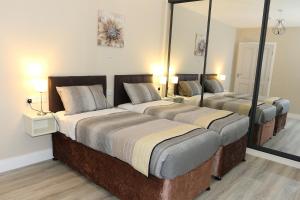 two beds in a room with two mirrors at Coaches Corner - Accessible Self-Catering Guest Suite - 5 Minutes from town - Singles or Super-King in Castleblayney