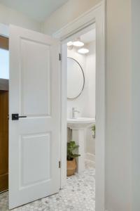 a white door leading to a bathroom with a sink at Farmhouse Fresh 4BR Retreat in University Heights