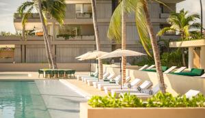 a swimming pool with lounge chairs and umbrellas at Anera Villas in Barra de Potosi