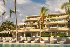 a hotel with a swimming pool and palm trees at Anera Villas in Barra de Potosi