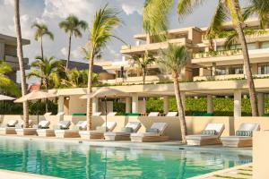 a hotel with a swimming pool and palm trees at Anera Villas in Barra de Potosi