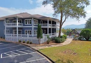 a large blue house with a porch and a parking lot at The Ellijay Resort in Ellijay