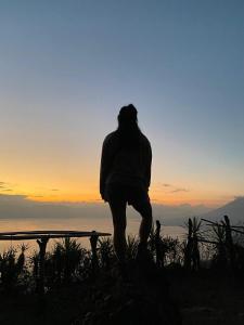 ein Mann, der auf einer Bank steht und den Sonnenuntergang betrachtet in der Unterkunft Hiking San Juan in Cataltzul