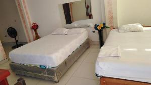 two twin beds in a room with a mirror at HOSPEDAJE MARISCAL CASTILLA in Tumbes