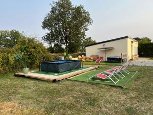 a backyard with two lawn chairs and a trampoline at La villa Lambert - Le Loft in La Ferté-Fresnel +12 photos