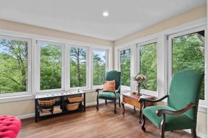a living room with windows and a table and chairs at Little Birds Nest in Highlands
