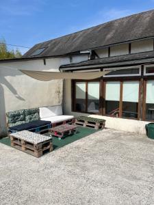 a building with a couch and tables in front of it at La villa Lambert-Longière in Monnai