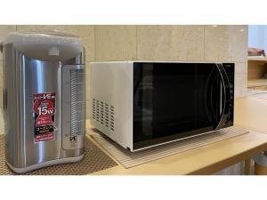 eine Mikrowelle auf einer Theke neben einem Mülleimer in der Unterkunft Smile Hotel Shizuoka - Vacation STAY 76993v in Shizuoka