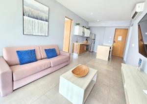 a living room with a pink couch and a table at The best location in Playa Downtown 2Br Condo in Playa del Carmen
