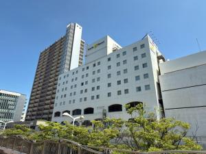 a large white building with two tall buildings at Smile Hotel Shimonoseki - Vacation STAY 96720v in Shimonoseki