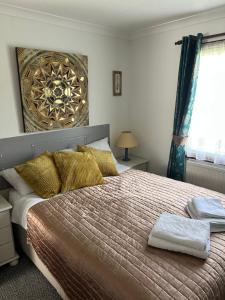 a bedroom with a large bed with gold pillows at Sunshine Lodge Haven Lakeland in Flookburgh +39 photos