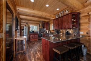 a kitchen with wooden cabinets and a island in a log cabin at Little Deschutes Wildlife Lodge - Nature's Cabin in La Pine