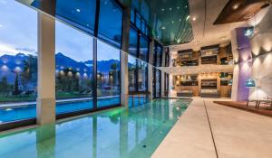 una piscina cubierta en un edificio con ventanas grandes en Hotel Schwefelbad (Schenna Resort), en Scena